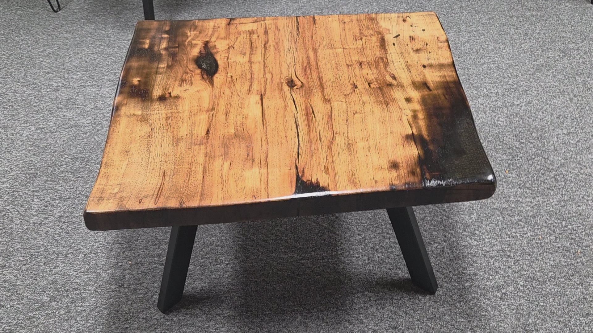 Pecan coffee table with a rustic finish and sho sugi bon treatment with black metal legs