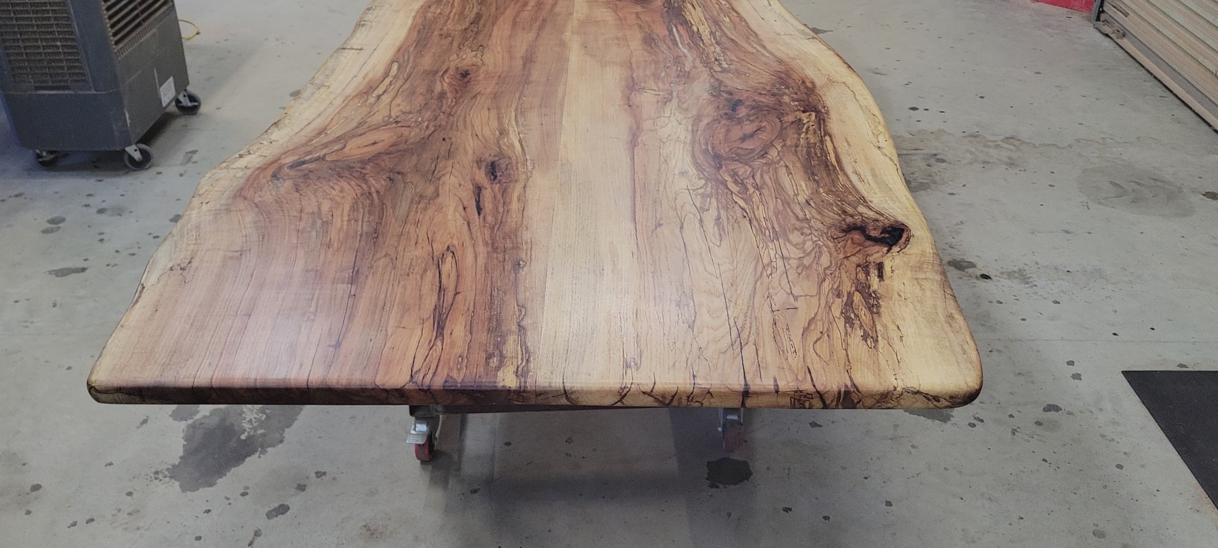 A large live-edge Pecan dining table with matching bench seats, in the natural color with x-style black metal legs
