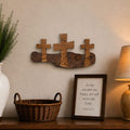 A rustic wooden console table styled in a warm, home-like setting with a white ceramic vase, a wicker basket, a framed scripture print, and a lit table lamp against a beige wall.